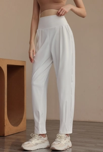 Detailed close-up of high-waisted white nylon sports trousers with elegant vertical seams
