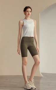 Détail du débardeur de sport blanc et du short de yoga vert taille haute avec poches