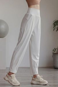 Detailed side view of high-waisted white nylon joggers with side pockets for women