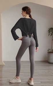 Detail of loose yoga top with open back tie design and high waist fitness leggings