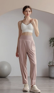 Detail of high waist pleated pink yoga pants and white ribbed vest on a model
