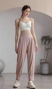 Detailed view of high-waist loose yoga pants and white sports bra on a female model