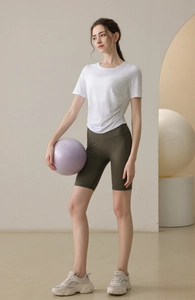 Détail du t-shirt de yoga blanc cintré avec fronces et short de cycliste vert