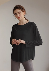 Close-up of black tencel long sleeve sports top featuring loose fit and round neckline