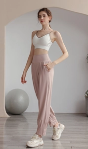 Close-up of high-waist elastic waistband and side pockets on pink nylon joggers