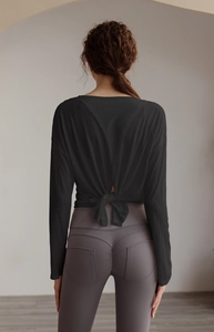 Close-up of black long-sleeve yoga top featuring a stylish back cross tie knot detail
