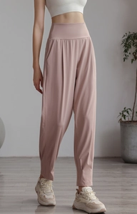 Detail view of high-waisted pale pink yoga joggers with elastic cuffs and wide waistband