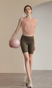 Detail view of pink sleeveless yoga crop top and olive green high waist cycling shorts