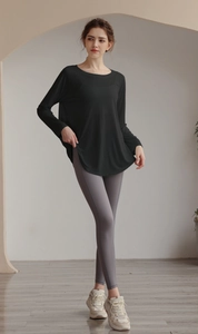 Relaxed fit black yoga long sleeve top paired with grey leggings for gym workout