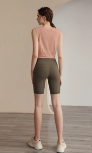 Rear view of a fitness set featuring a pink crop tank top and olive green biker shorts
