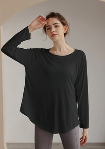 Detail view of black loose-fit yoga top with irregular hem and soft tencel fabric texture