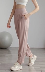 Detail of high waisted dusty rose yoga pants featuring side pockets and elastic fabric