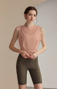 Detail of pink crop top hem and olive green high-waisted fitness cycling shorts