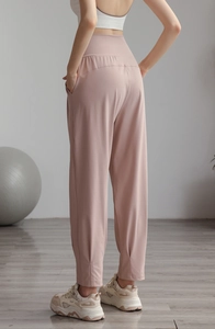 Detail of high waisted yoga joggers in dusty pink with side pockets and cinched cuffs
