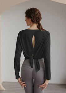Detail of yoga top with back cutout design and high waist purple compression leggings