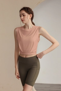 Close-up of pink sleeveless sports tank top and green yoga shorts with side pocket