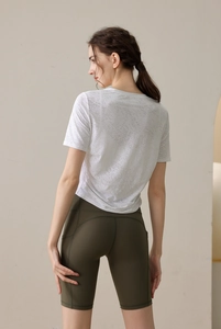 Détail du haut en mesh blanc respirant et du short de yoga vert olive avec poche latérale