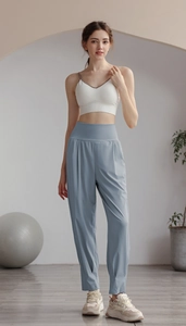 High-waisted blue jogging pants and white ribbed tank top in a cozy yoga setting