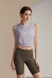 Detail of lavender sleeveless workout top and olive green high-waisted cycling shorts