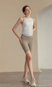 Detailed view of women's white racerback yoga vest and khaki high-waisted shorts with pockets