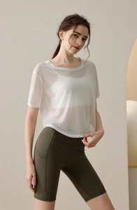 Detail eines weißen Yoga-Überwurfs über olivgrüner Radlerhose mit Seitentaschen