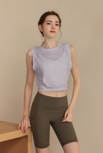 Detail of loose fit lavender yoga tank top and green high waist cycling shorts