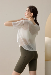 Detailansicht eines semitransparenten Yoga-T-Shirts und grünen High-Waist-Fitness-Shorts