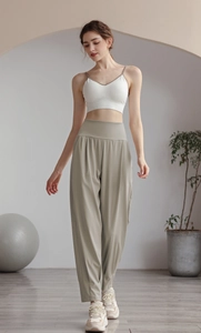 Detail of high-waisted olive green wide-leg yoga pants and white V-neck sports camisole top