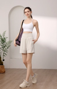 Detail view of high waist yoga shorts and white racerback sports top set on model