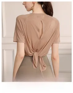 Detail of female yoga top showing the adjustable tie-back design and breathable fabric