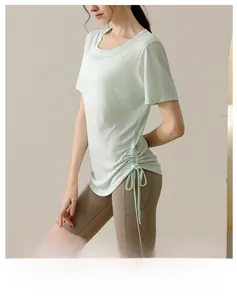 Detail of light green yoga top showing adjustable side drawstring and breathable fabric