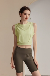 Detail of lime green sleeveless workout top with stylish pleated hem for women