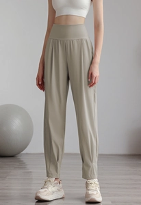 Detail showing the vertical pleated design and high-waist band on the green yoga joggers