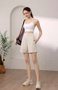Close-up of high-waisted beige nylon yoga shorts with a wide waistband and loose fit