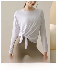 Detail of white modal yoga top featuring a stylish side split and knot tie design