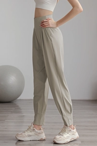 Detail view of high-waisted nylon joggers featuring wide waistband and side pockets