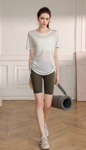 Detail view of white drawstring yoga top and olive green high waist biker shorts set