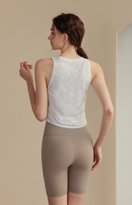 Back view of a white jacquard yoga tank top and khaki high-waisted fitness shorts