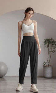 Detail view of the wide high-waist band on black nylon sports joggers and white sports bra