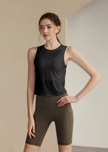 Détail du débardeur en maille noire respirante et du short de yoga vert olive avec poche latérale