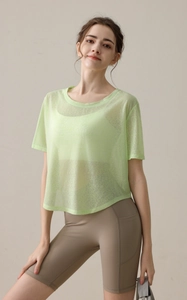 Detail von hellgrünem Mesh-Yoga-T-Shirt und erdfarbenen High-Waist-Sportshorts für Damen