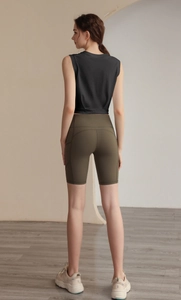 Detail of loose fit sleeveless sports tank top and green high waist cycling shorts