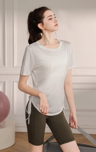Detail of white t-shirt with side drawstring and green yoga shorts for fitness training