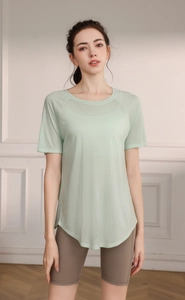 Detail of light green breathable yoga top with side slit and rounded hem for women