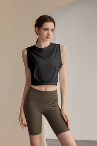 Close-up of black sleeveless crop top and olive green high-waist yoga shorts for fitness