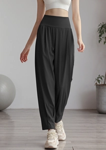Detail of high waisted black nylon jogger pants showing loose fit and soft fabric texture