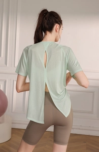 Detail view of mint green yoga tee with large back slit and breathable mesh fabric texture