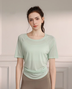 Detail of mint green breathable yoga top showing mesh texture and side slit design