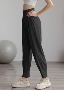 Detail view of high waisted black joggers featuring refined pleated ankle cuff stitching