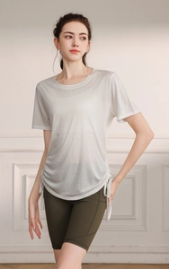Detail of adjustable side drawstring and breathable fabric on a gray sports yoga t-shirt